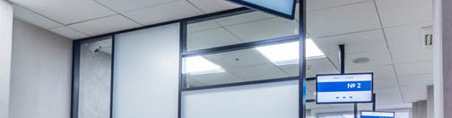 Modern cubicle office with high  black and white glass panels  and digital signages